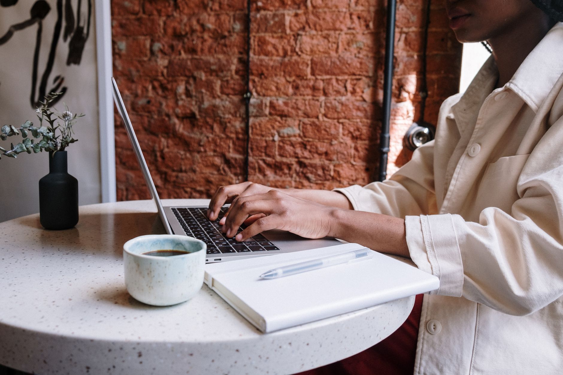 Person typing a blog prompt into ChatGPT on a laptop at a desk