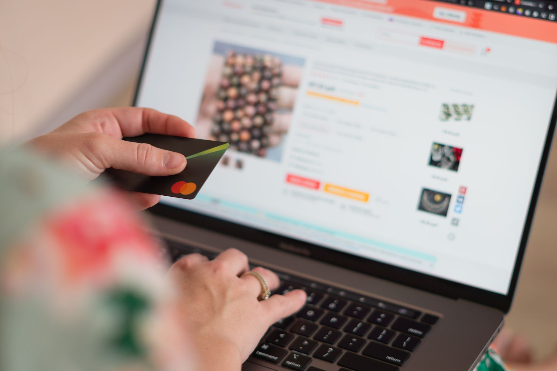 Person typing on a laptop while viewing an ecommerce product catalog screen