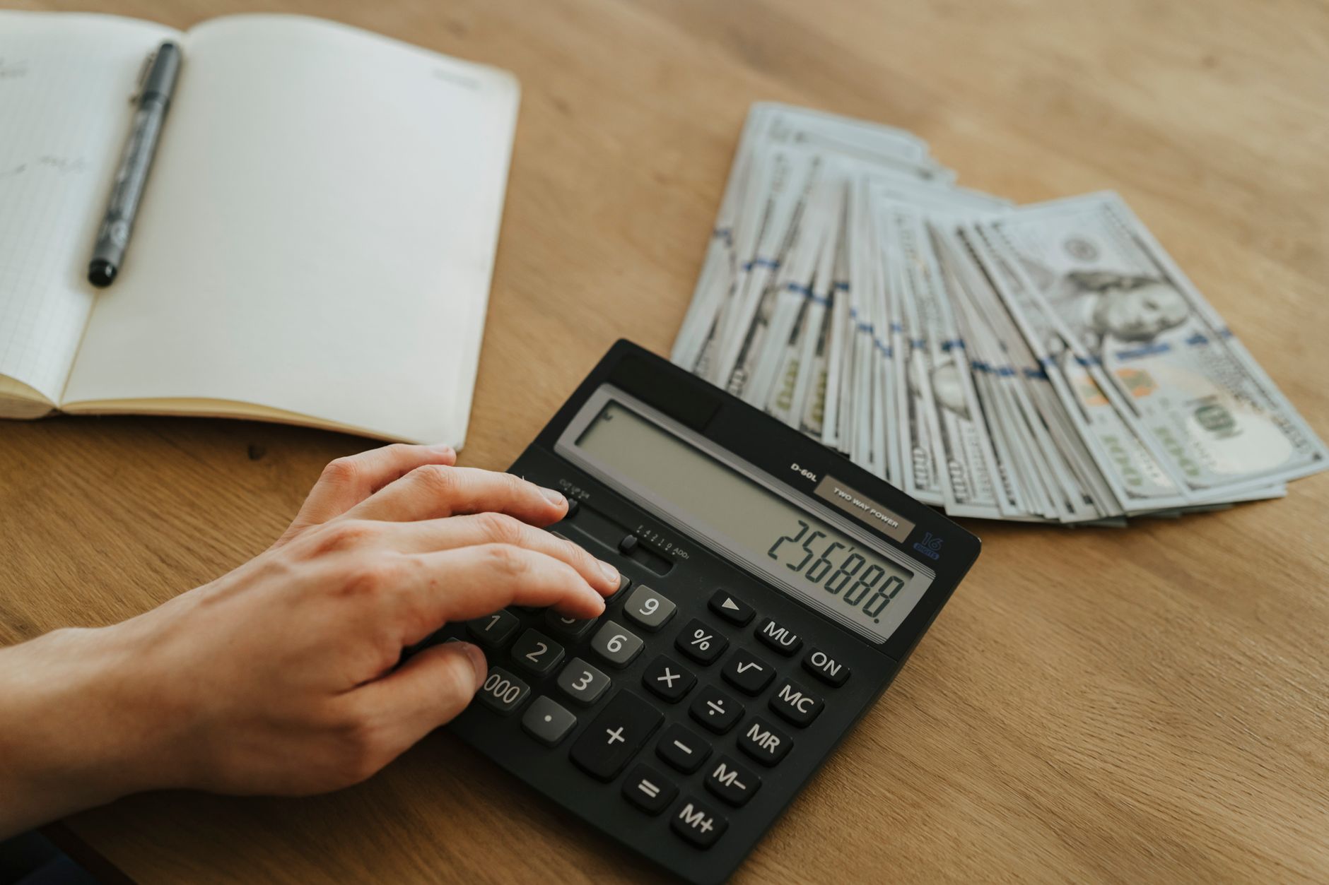 Accountant reviewing an expense report on a laptop while holding paper receipts