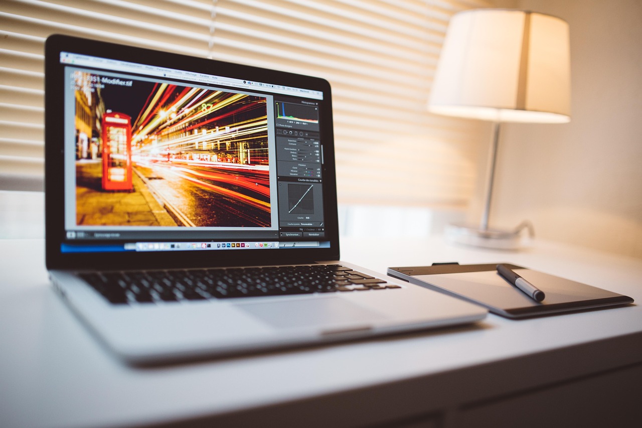 A digital artist draws a colorful futuristic cityscape on a graphics tablet.