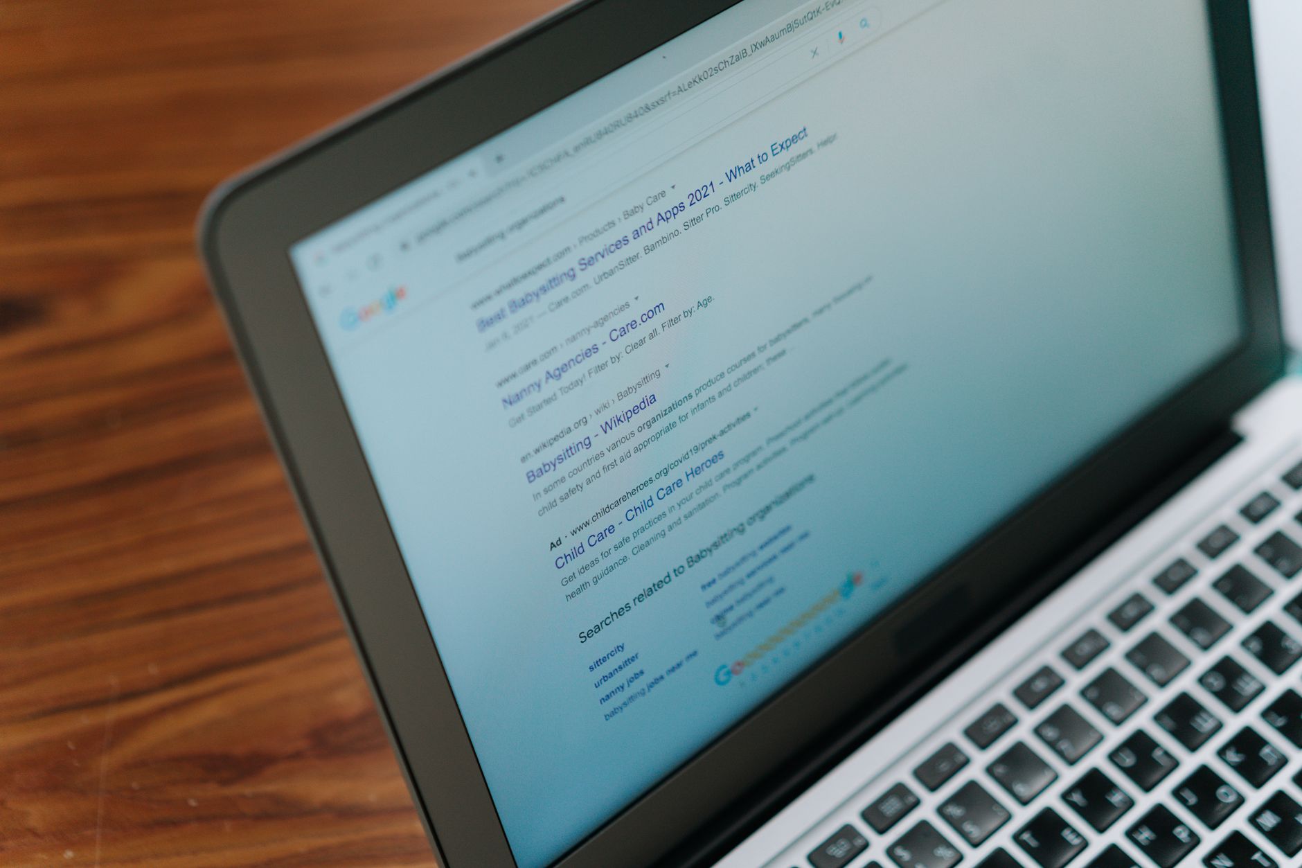 Person typing a search query on a laptop while reading cited AI search results
